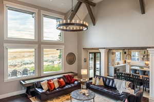 Living room with plenty of natural light, wood-type flooring, and a high ceiling