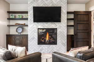 Living room with a tiled fireplace and built in shelves