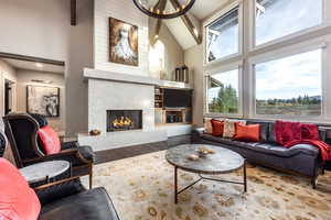 Living room with beamed ceiling, a premium fireplace, hardwood / wood-style floors, and high vaulted ceiling