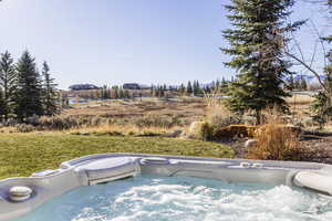 View of swimming pool with a hot tub