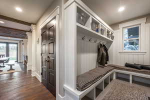 Mudroom with dark hardwood / wood-style flooring and decorative columns