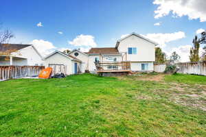 Back of house with a yard and a wooden deck