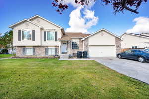 Split level home with a front yard and a garage