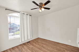 Spare room with hardwood / wood-style floors, a textured ceiling, and ceiling fan