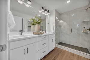 Bathroom with vanity, wood-type flooring, and an enclosed shower