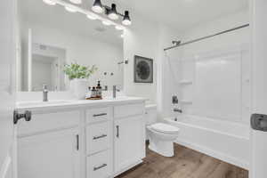 Full bathroom featuring shower / bathing tub combination, vanity, hardwood / wood-style flooring, and toilet