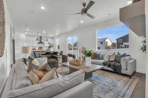 Living room with carpet flooring and ceiling fan