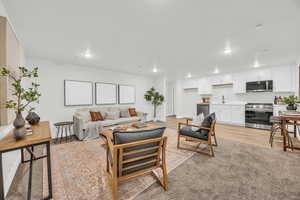 Living room featuring sink and light hardwood / wood-style flooring