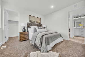 Carpeted bedroom with a spacious closet and a closet