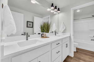 Full bathroom with vanity, hardwood / wood-style flooring, toilet, and tub / shower combination