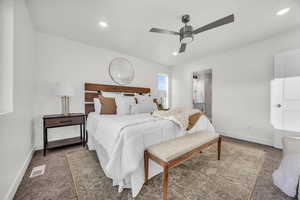 Bedroom featuring ceiling fan, carpet floors, and ensuite bathroom