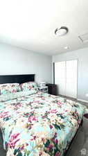 Bedroom featuring dark hardwood / wood-style floors, a textured ceiling, and a closet