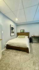 Bedroom with a paneled ceiling and carpet flooring