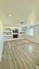 Unfurnished living room featuring hardwood / wood-style flooring and a textured ceiling