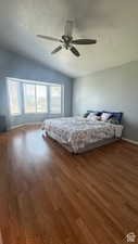 Unfurnished bedroom with hardwood / wood-style floors, a textured ceiling, ceiling fan, and lofted ceiling