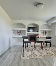 Dining area with a textured ceiling, light hardwood / wood-style floors, and built in features