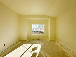 Empty room with lofted ceiling