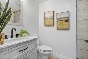 Bathroom featuring hardwood / wood-style floors, vanity, and toilet