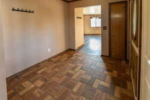 Empty room with dark parquet flooring and an inviting chandelier