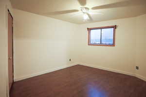 Spare room with ceiling fan and dark wood-type flooring