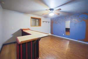 Interior space featuring a textured ceiling, ceiling fan, and wood-type flooring