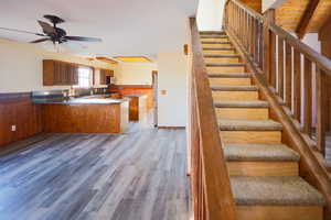 Kitchen featuring hardwood / wood-style floors, kitchen peninsula, ceiling fan, a breakfast bar, and sink