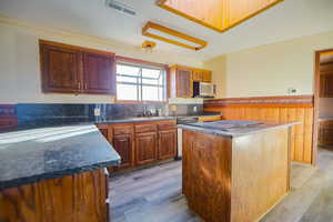 Kitchen featuring light hardwood / wood-style flooring, dishwasher, sink, and a kitchen island