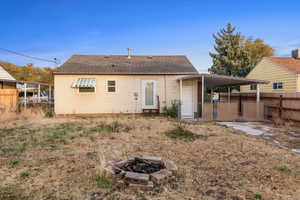 Rear view of property featuring a fire pit and a carport