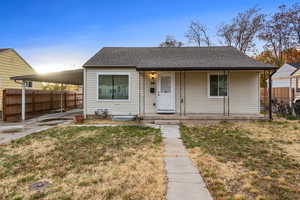 View of front of house featuring a front yard, a porch, and a carport