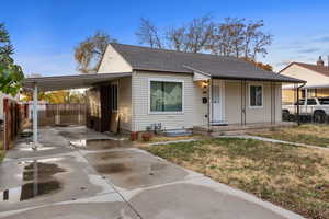 View of front of property with a front yard and a carport