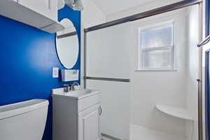 Bathroom featuring vanity, toilet, and walk in shower