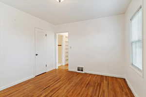 Empty room with hardwoodand a wealth of natural light