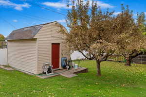 View of large shed with a lawn and apple tree