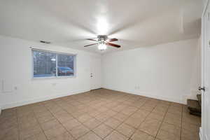 Tiled spare room with ceiling fan