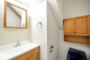 Bathroom with vanity and lofted ceiling