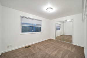 Unfurnished bedroom with carpet and a closet