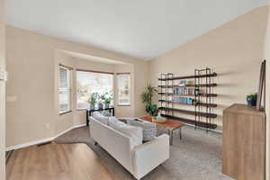 Living room with light wood-type flooring and lofted ceiling