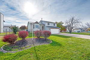 View of front of home featuring a garage and a front lawn