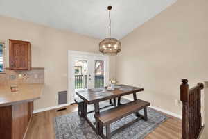 Dining space featuring a chandelier, light wood-type flooring, and french doors