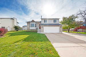 View of front of home featuring a garage and a front yard