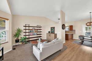 Living room with light hardwood / wood-style flooring and vaulted ceiling