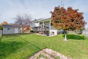 View of yard with a storage shed and a wooden deck