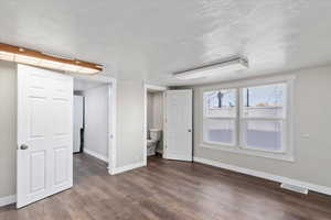 Interior space featuring connected bathroom and wood-type flooring