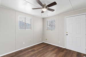 Spare room featuring dark hardwood / wood-style flooring, a wealth of natural light, and ceiling fan