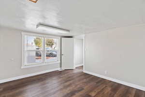 Empty room with dark hardwood / wood-style flooring