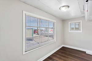 Empty room with plenty of natural light and dark wood-type flooring