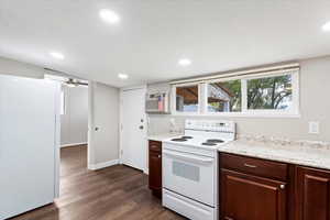 Kitchen with white appliances, dark wood-type flooring, ceiling fan, a textured ceiling, and dark brown cabinets