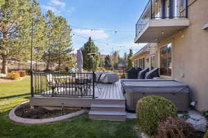 Deck with a lawn and a hot tub