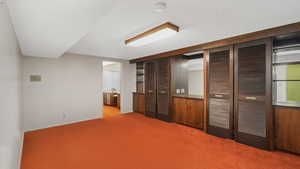 Interior space with carpet floors and a textured ceiling.  2 Murphy beds