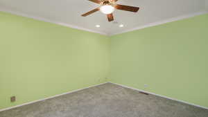 Unfurnished room with ceiling fan, ornamental molding, and light carpet